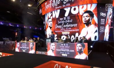 Wide shot of the press conference stage for Teofimo Lopez vs Shakur Stevenson with promotional graphics on screen.