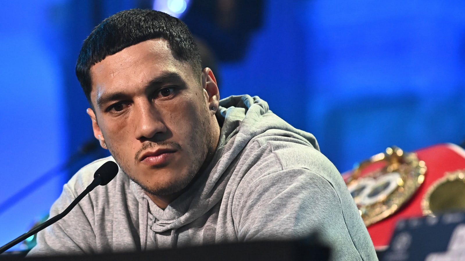 Jai Opetaia speaks at a press conference with the IBF cruiserweight title belt behind him