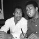 Muhammad Ali and Ken Norton seated together at a press event in 1973