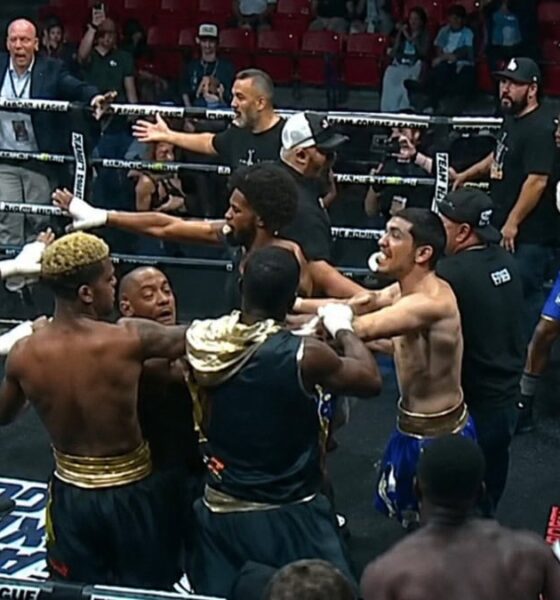 Multiple boxers and team members confront each other inside the ring during a Team Boxing League event as officials attempt to separate them in the chaos
