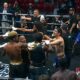 Multiple boxers and team members confront each other inside the ring during a Team Boxing League event as officials attempt to separate them in the chaos