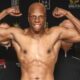 Atif Oberlton flexes during an official weigh-in with Dmitriy Salita standing behind him.