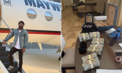 Floyd Mayweather stands beside a private jet while stacks of cash and luxury watches sit on a table amid growing scrutiny over the boxer's finances