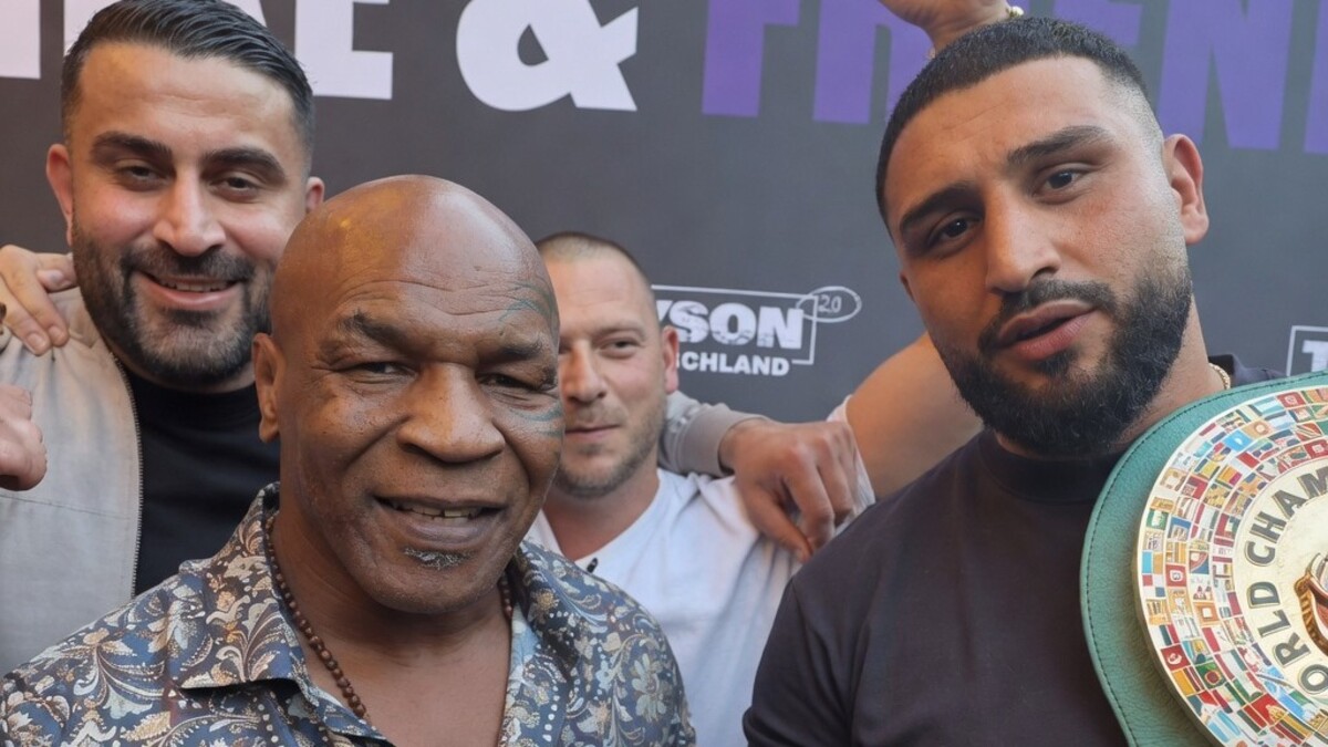 Mike Tyson poses with WBC mandatory heavyweight challenger Agit Kabayel as the German contender displays a championship belt during a public appearance in Germany