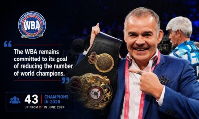 Gilberto Mendoza holding a WBA title belt inside a boxing ring during a championship presentation