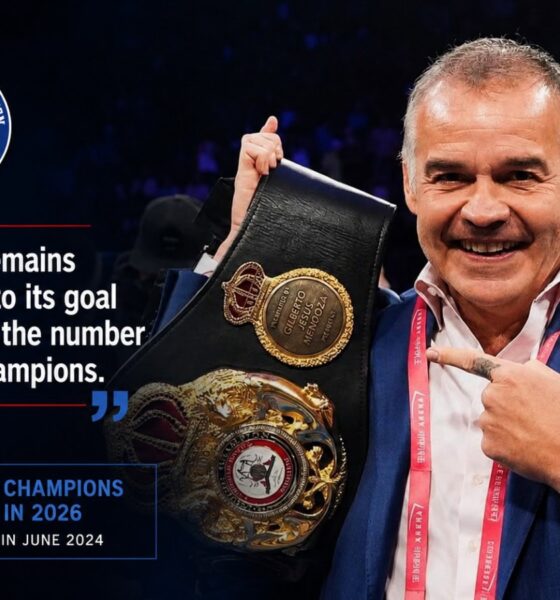 Gilberto Mendoza holding a WBA title belt inside a boxing ring during a championship presentation