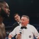 Deontay Wilder and Evgeny Romanov face off in the ring before their amateur bout, with a referee standing between the two fighters during the pre-fight instructions